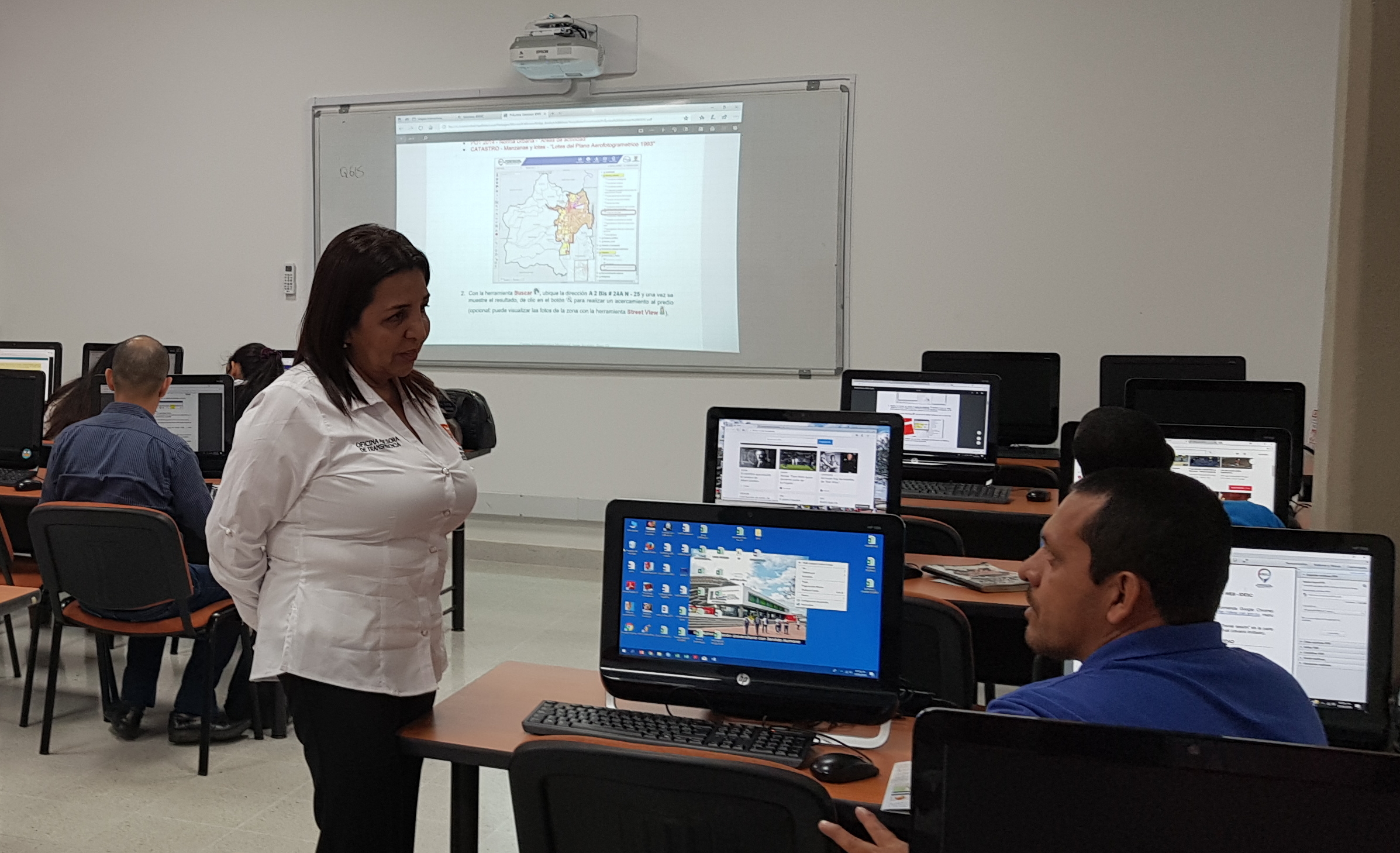 Hombre realizando una consulta a funcionaria de la Alcaldía durante el taller de la IDESC.