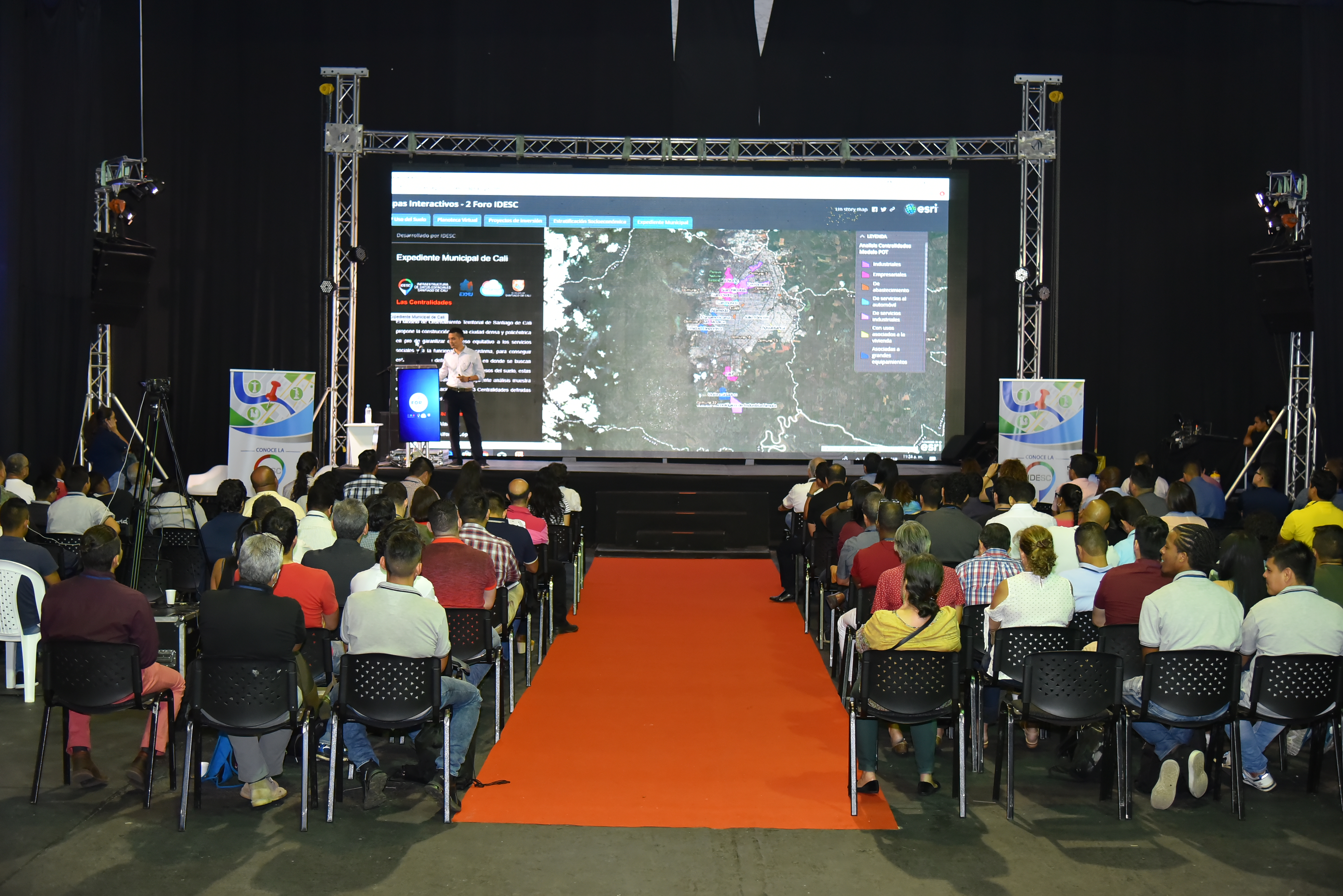 Imagen del evento, al fondo el escenario y expositor, al centro los participantes escuchando la conferencia.