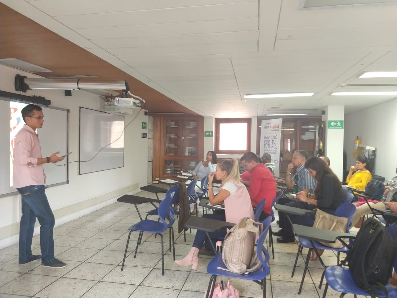 Fotografía de una jornada de socialización de la IDESC, en la cual los asistentes están prestando atención al expositor.